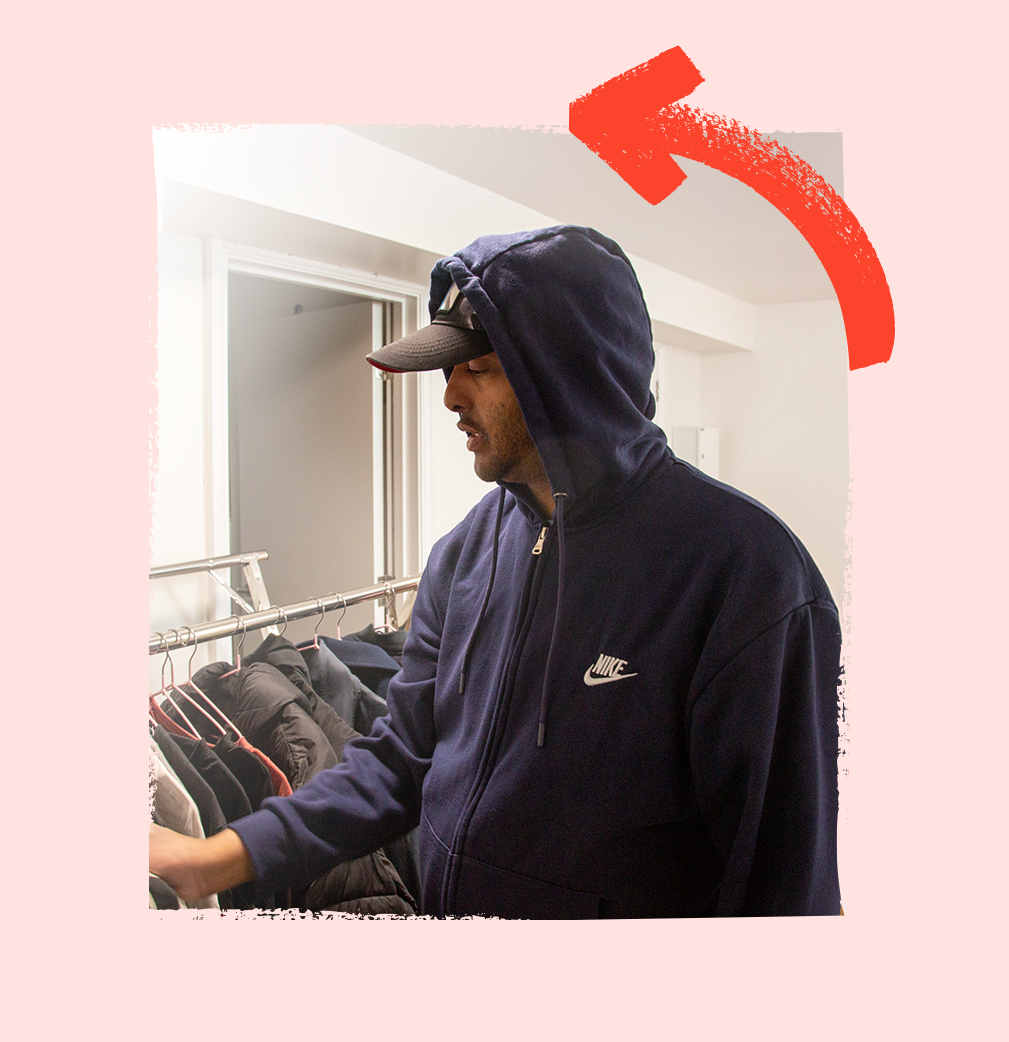 Service user selecting clothes from his wardrobe, thoughtfully choosing items to wear.