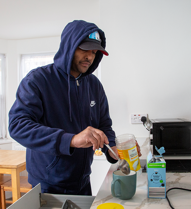 Service user preparing a cup of tea in a cozy kitchen setting